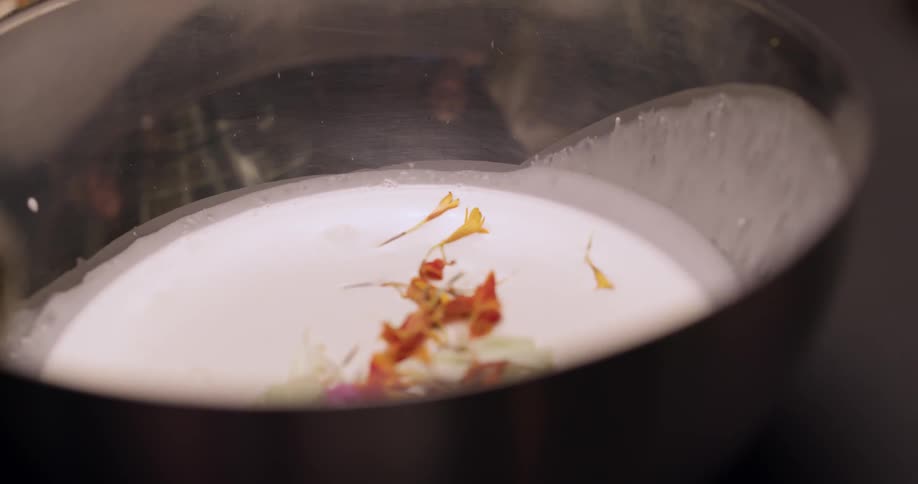 Petals are being sprinkled on top of a liquid mixture