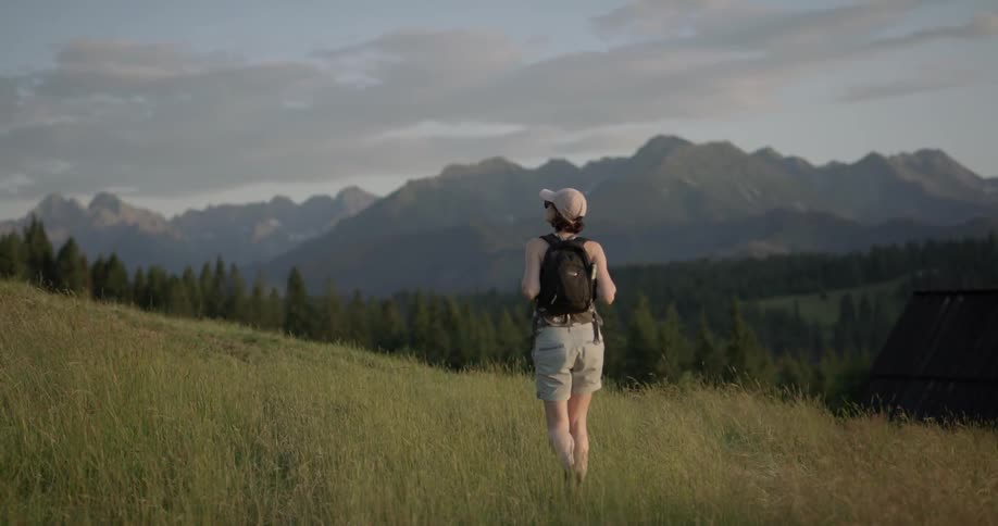 A woman is walking in a mountain area