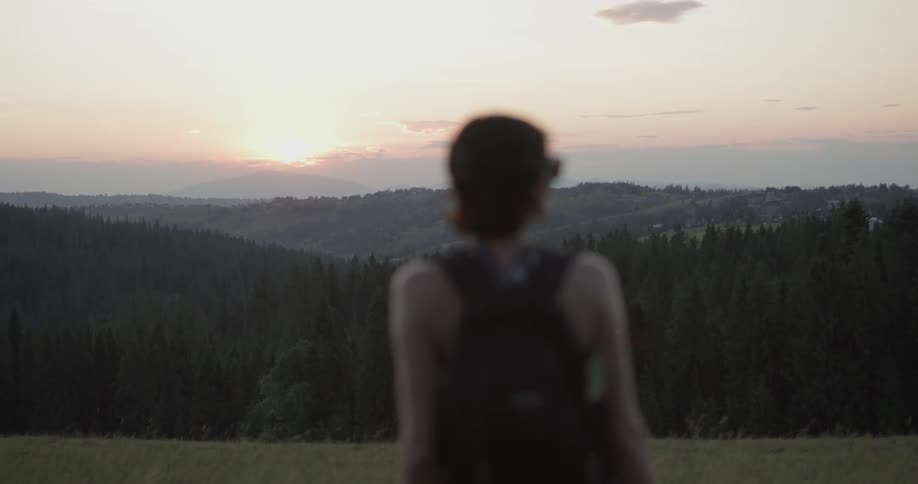 A woman looks to the distant hills