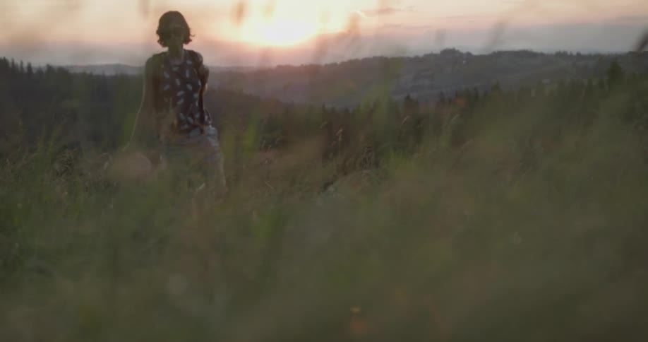 A woman walks through a field