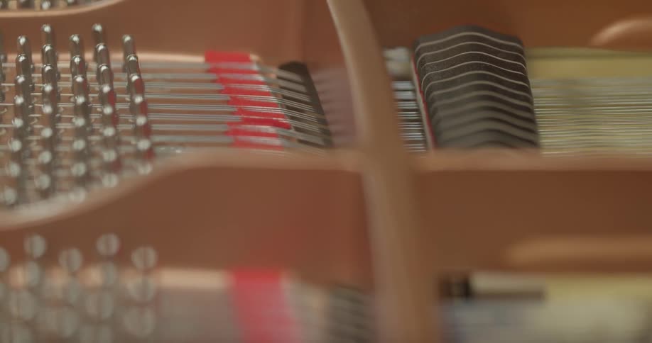 The hammers and strings inside of a piano move as the piano is played