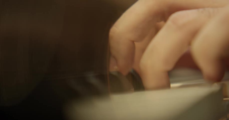 Fingers tapping and pressing white keys on a piano
