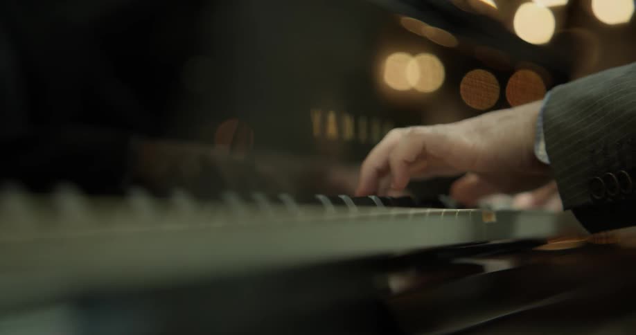 A white male playing a piano
