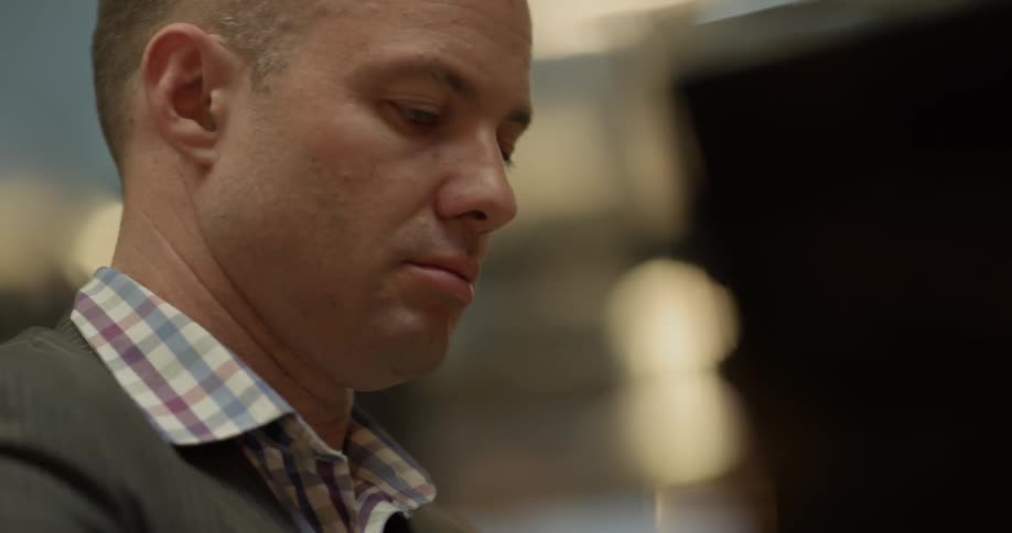 Bald man wearing blazer jacket and shirt play the piano indoors at night