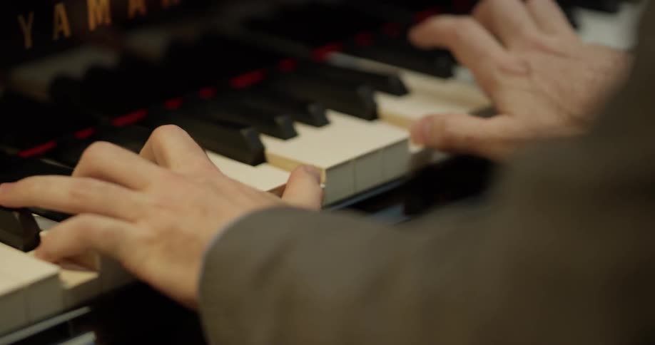 A pianist plays a yamaha grand piano