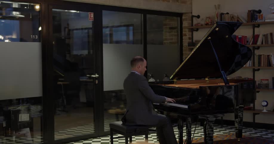 A man is playing piano in the shop