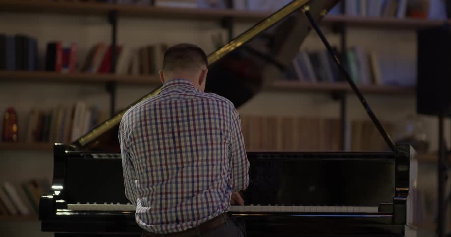 A man plays a grand piano