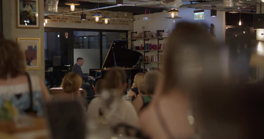 A man plays a piano in front of an audience