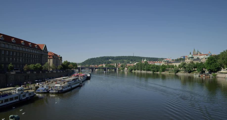 A canal in a picturesque town with large boats and buildings