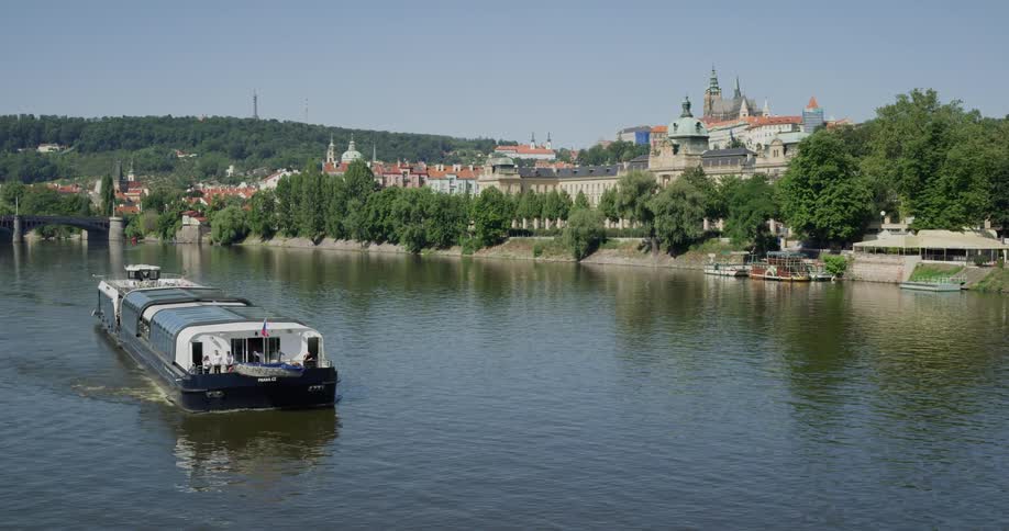A ship is sailing through the water near the coastal town