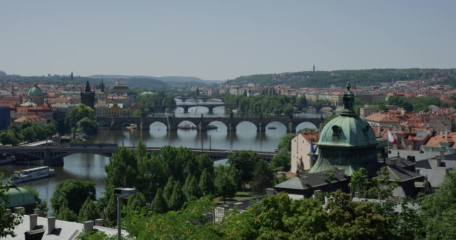 Several bridges with classical architecture span a river that connect parts of a european city with multiple historic landmark buildings