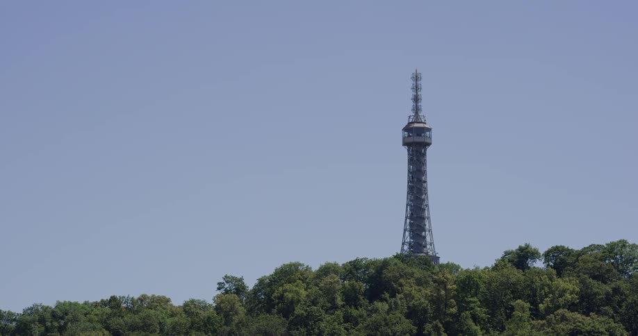 A metal tower with a platform on the top rises up from the woods