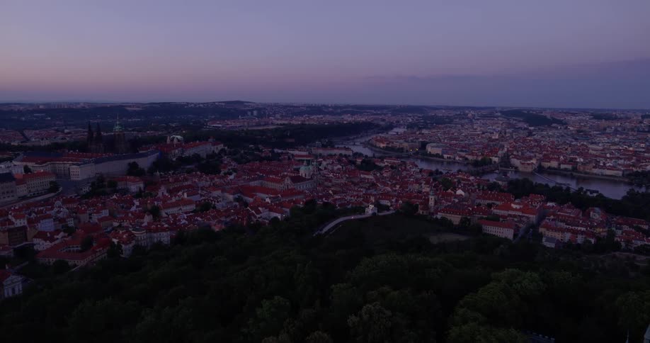 A city seen from atop a hill in the evening