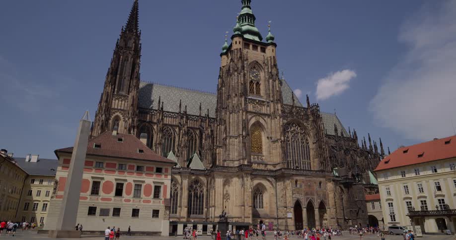 There are many people walking in front of the church
