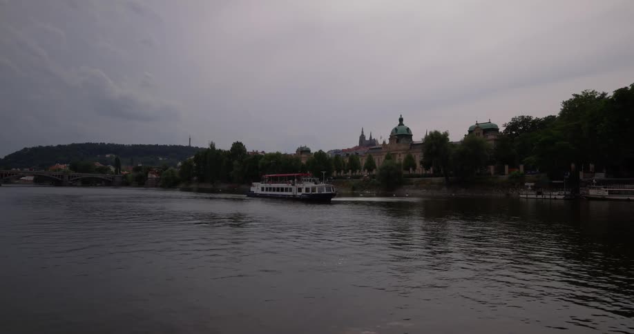 The ship is sailing past the town in the water