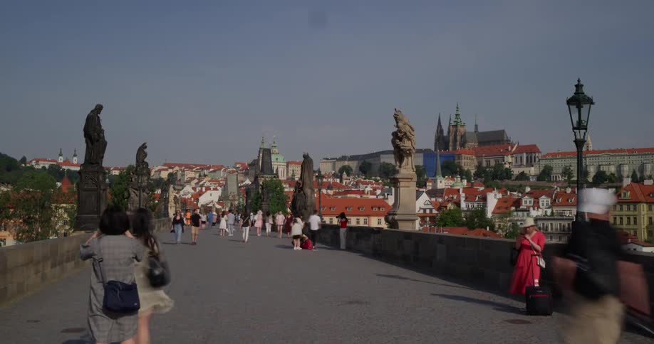 People crossing and taking photographs on a bridge in a city during the day