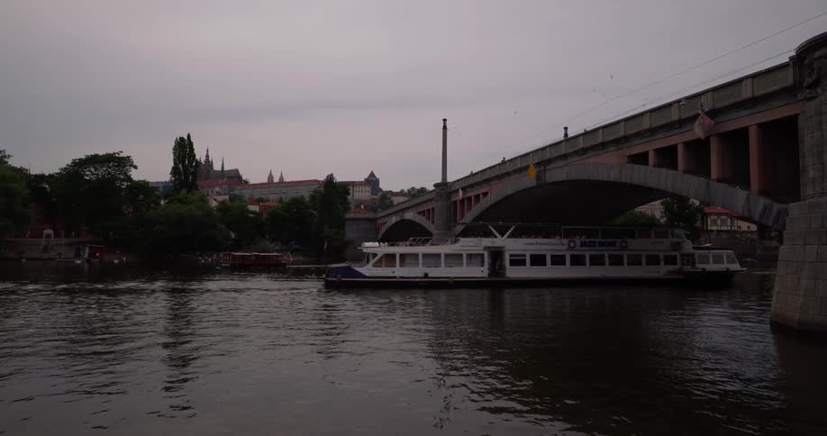 A river boat traveling under a bridge