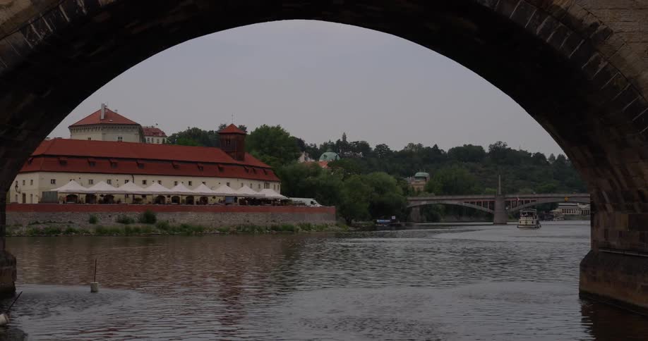 A river flows under a stone bridge next to a city