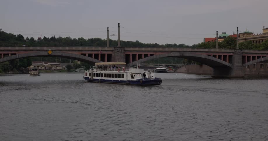 A river boat traveling under a bridge
