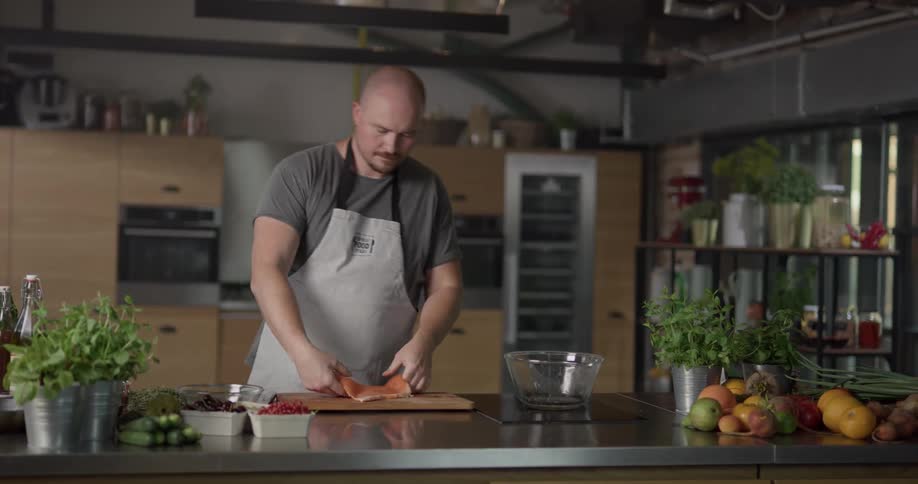A man skins a fish to get ready to cook it
