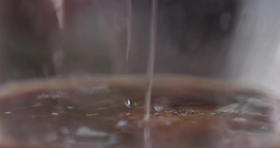 A person pours liquid into the bowl