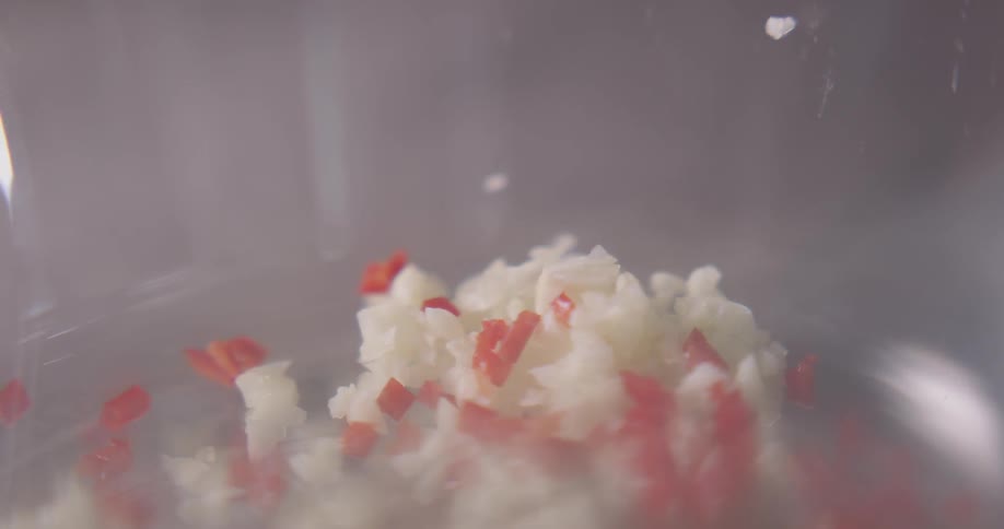 Minced garlic and minced chili peppers are dropped into a pan