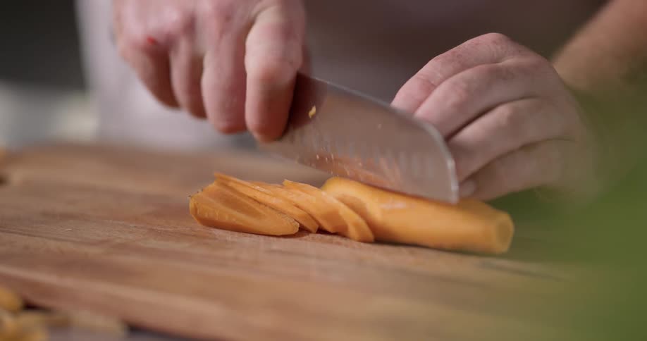 A man is cutting a carrot with a knife