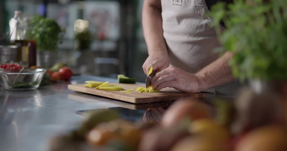 A man cuts a yellow squash
