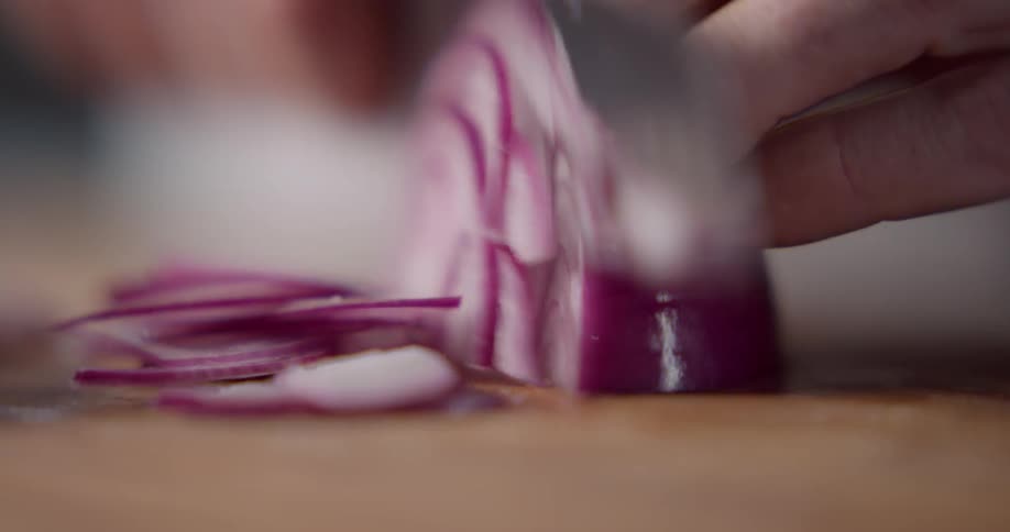 A man is cutting an onion
