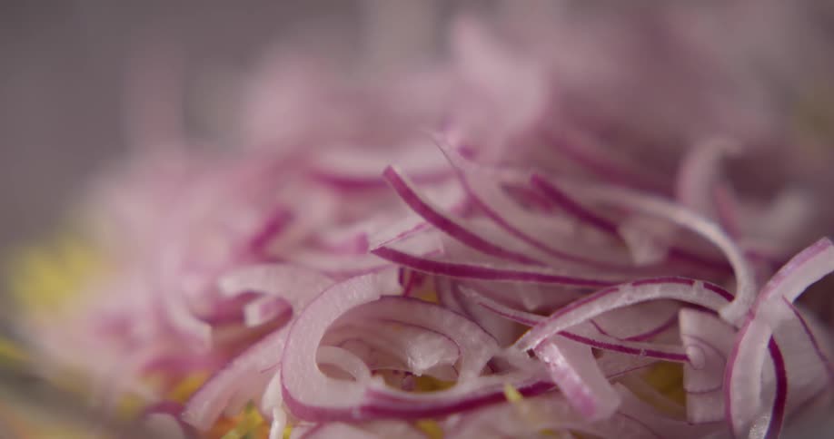 Man throws sliced onion on salad during daylight