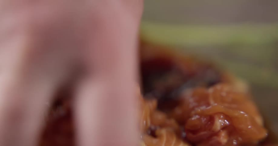 A person is mixing food with their hands