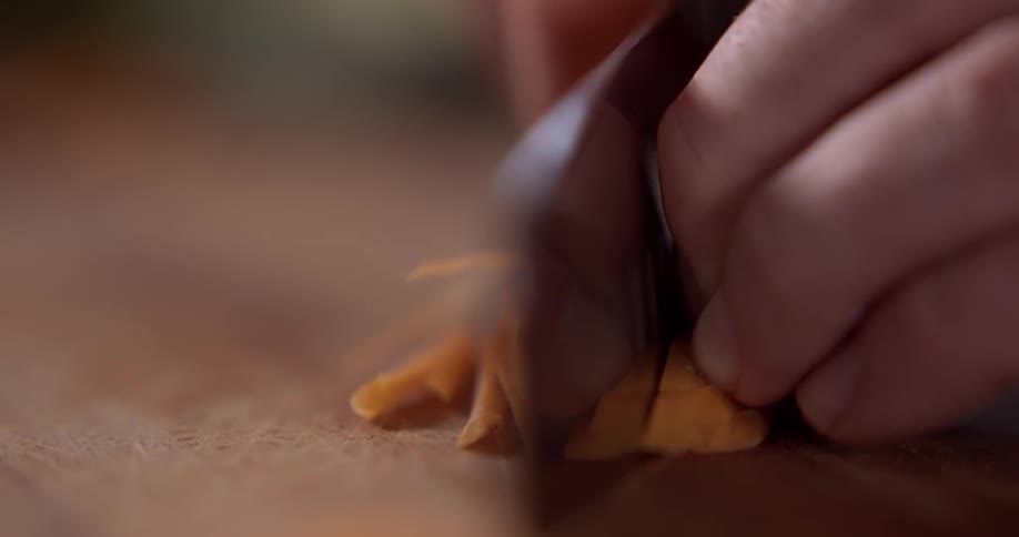 Carrots being sliced on a cutting board