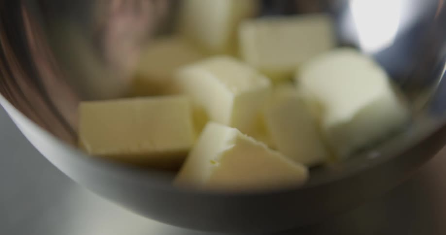A person picks up cheese from the bowl