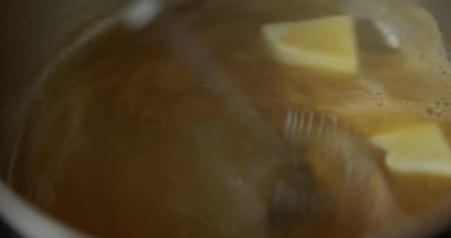 A chef whisking a sauce on a saucepan