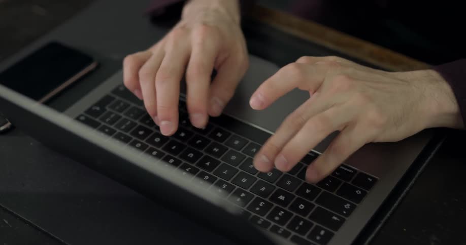 A person types on a laptop keyboard