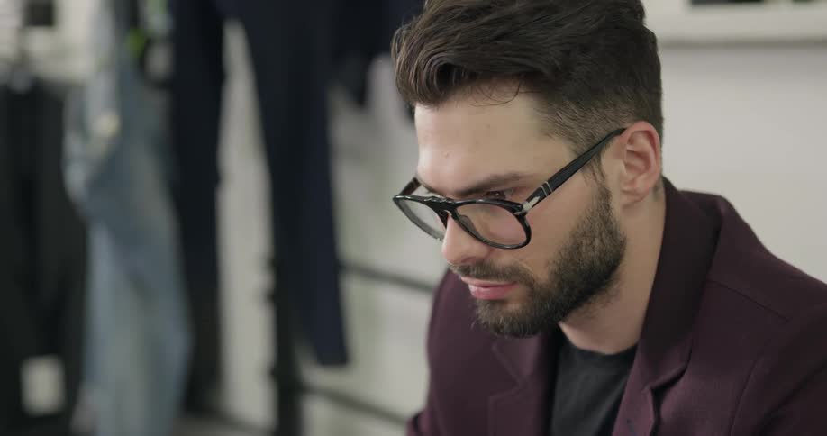 Man sits and studies in suit shop