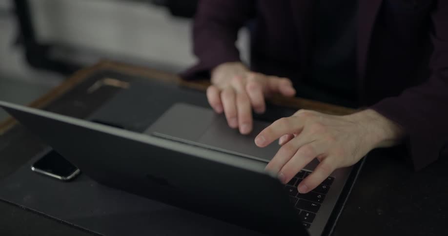 A man with glasses on a laptop