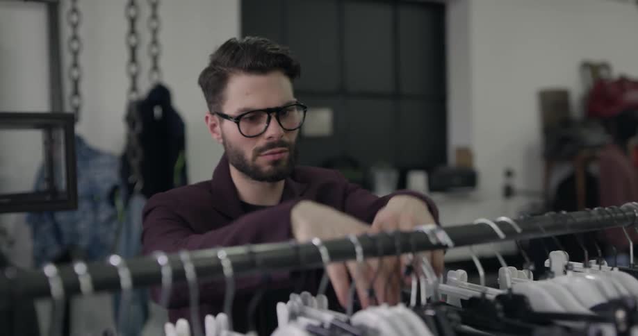 An employee hangs clothes in a store