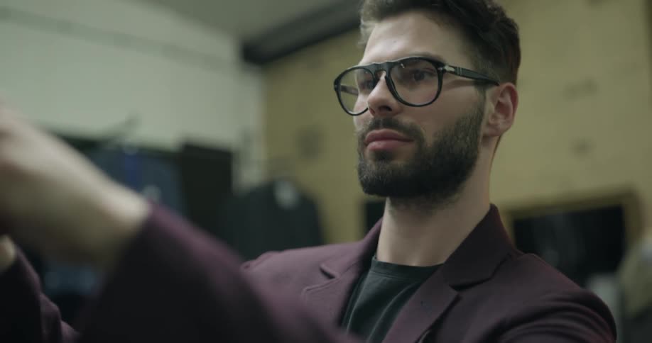 A man straightens a suit on a customer