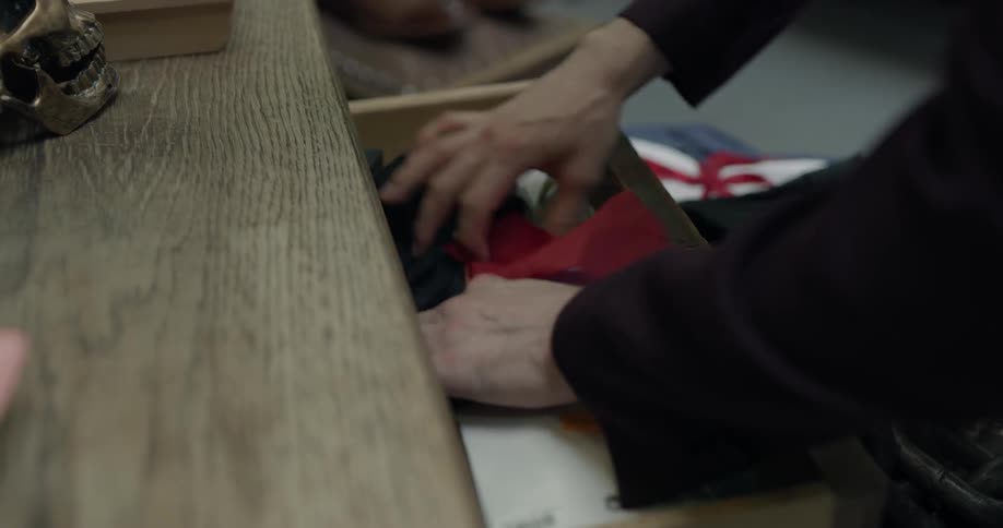 A man is looking through some drawers indoors