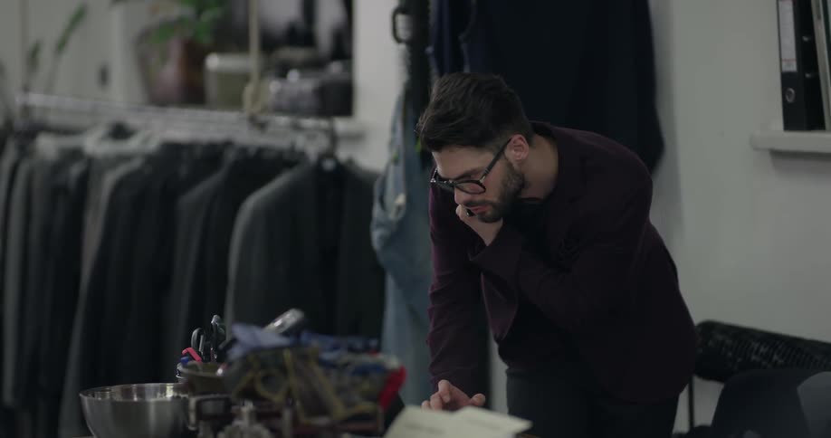 A man in a clothing store talks on the phone