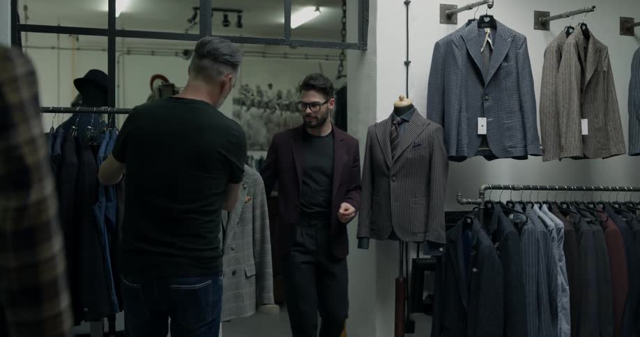A man walks over to look at shirts hanging on a rack