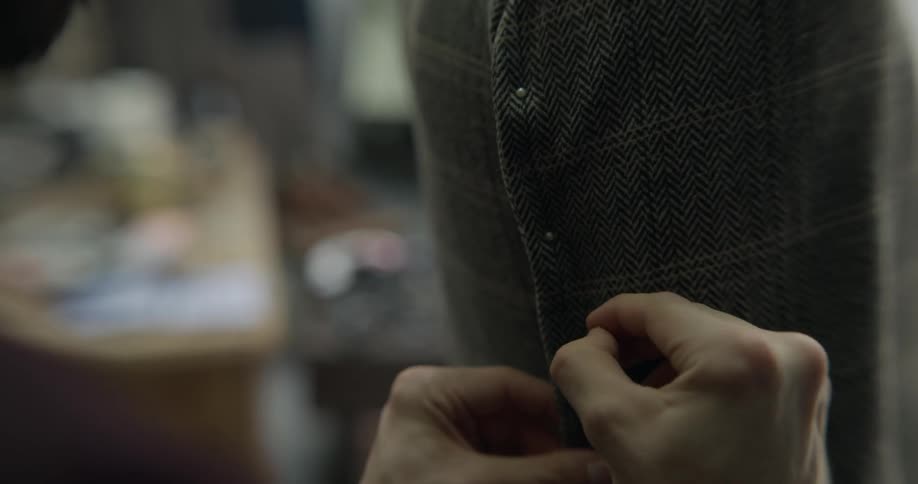 A man putting pins into a jacket