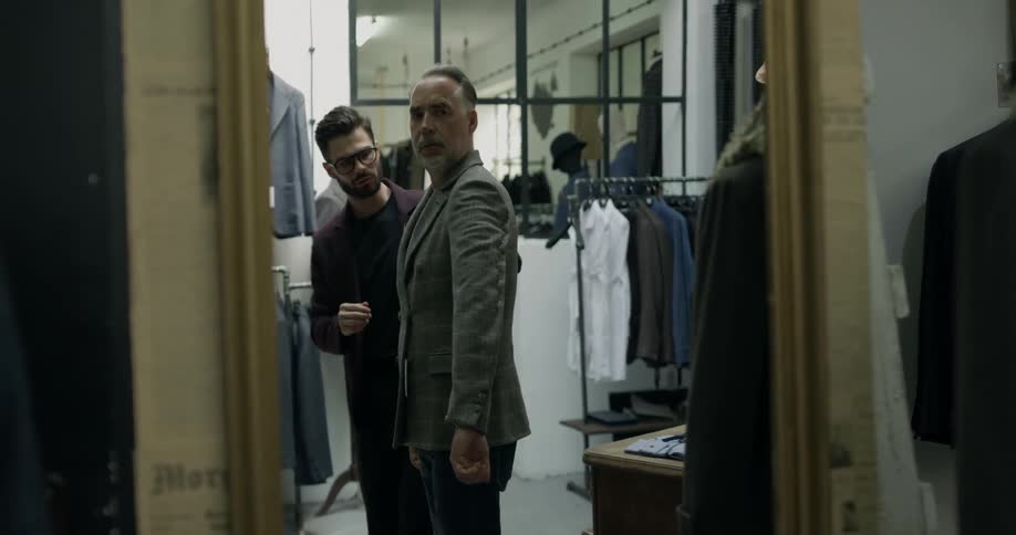Salesman adjust suit on customer