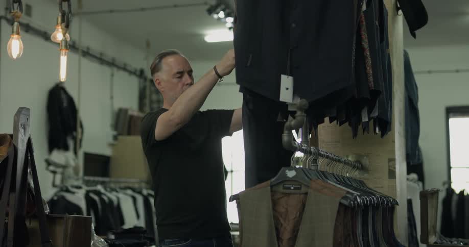 A man looking at a vest on a hanger