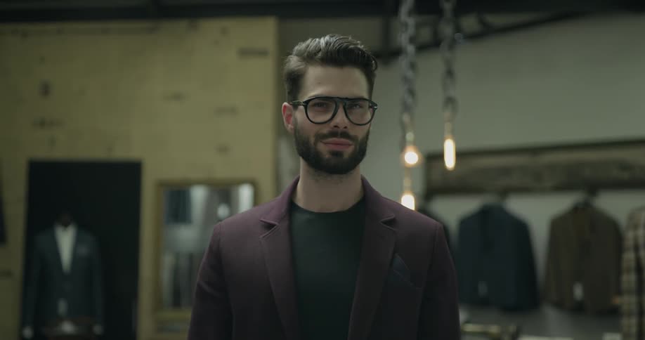 A man wearing glasses smirking at the camera
