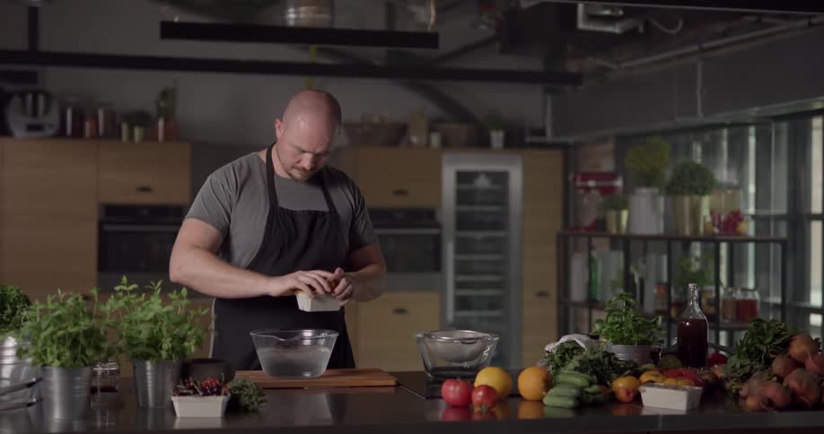 A man in a kitchen placing mushrooms in a bowl of water