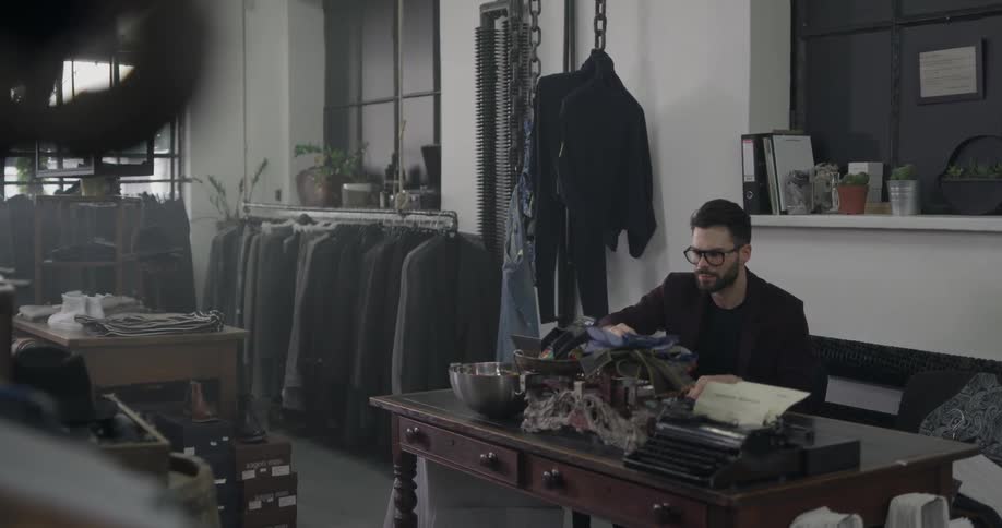 Man works at desk in suit shop