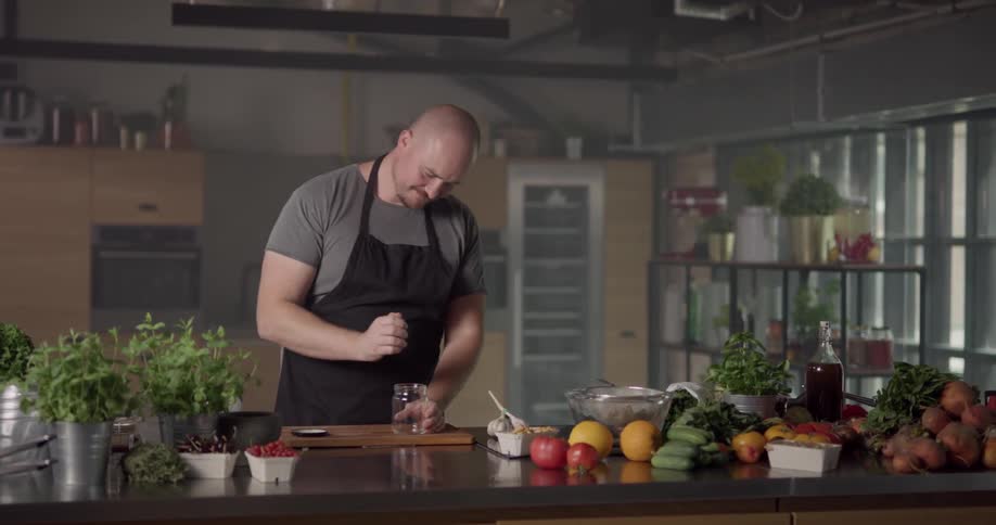 Man drops garlic head into jar and shake it