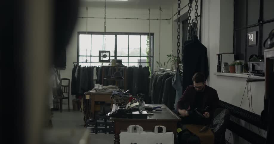 A man is placing clothes on hangers